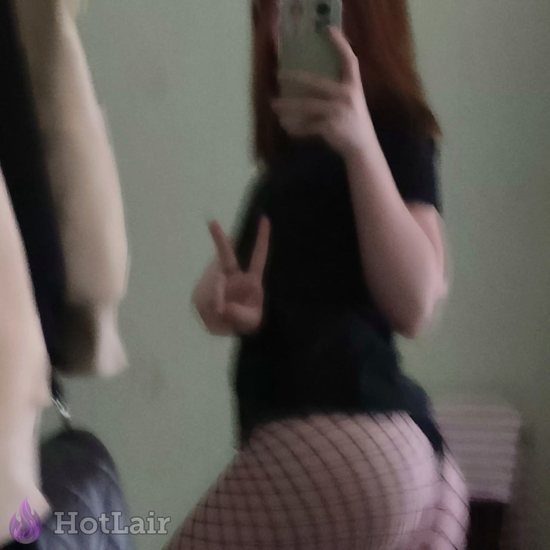 Selfie borroso en espejo de una en top negro y medias de red haciendo la señal de la paz