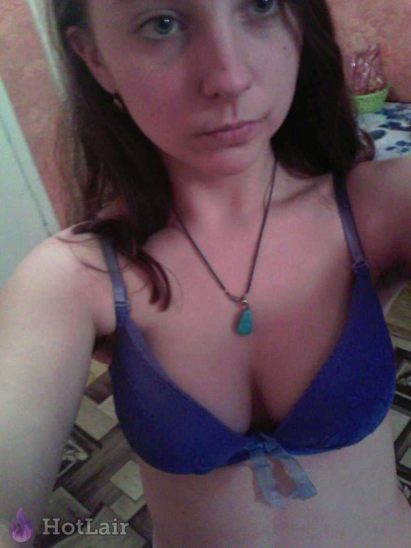 Mujer haciéndose selfie en sujetador azul con colgante de turquesa