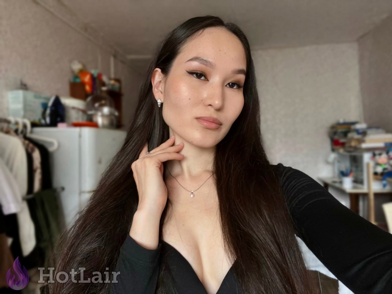atractiva de cabello largo oscuro en top negro escotado haciendo selfie en el espejo, mano en el cuello