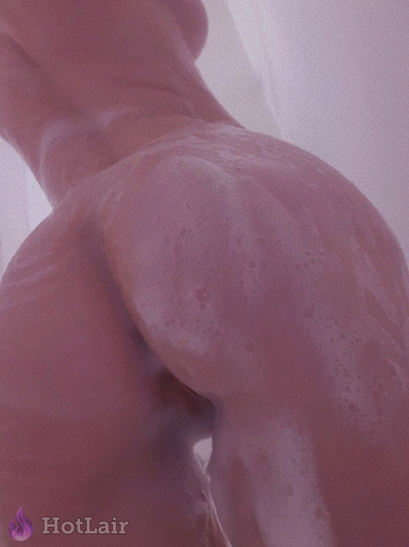 Primer plano de nalgas mojadas y enjabonadas de mujer en la ducha