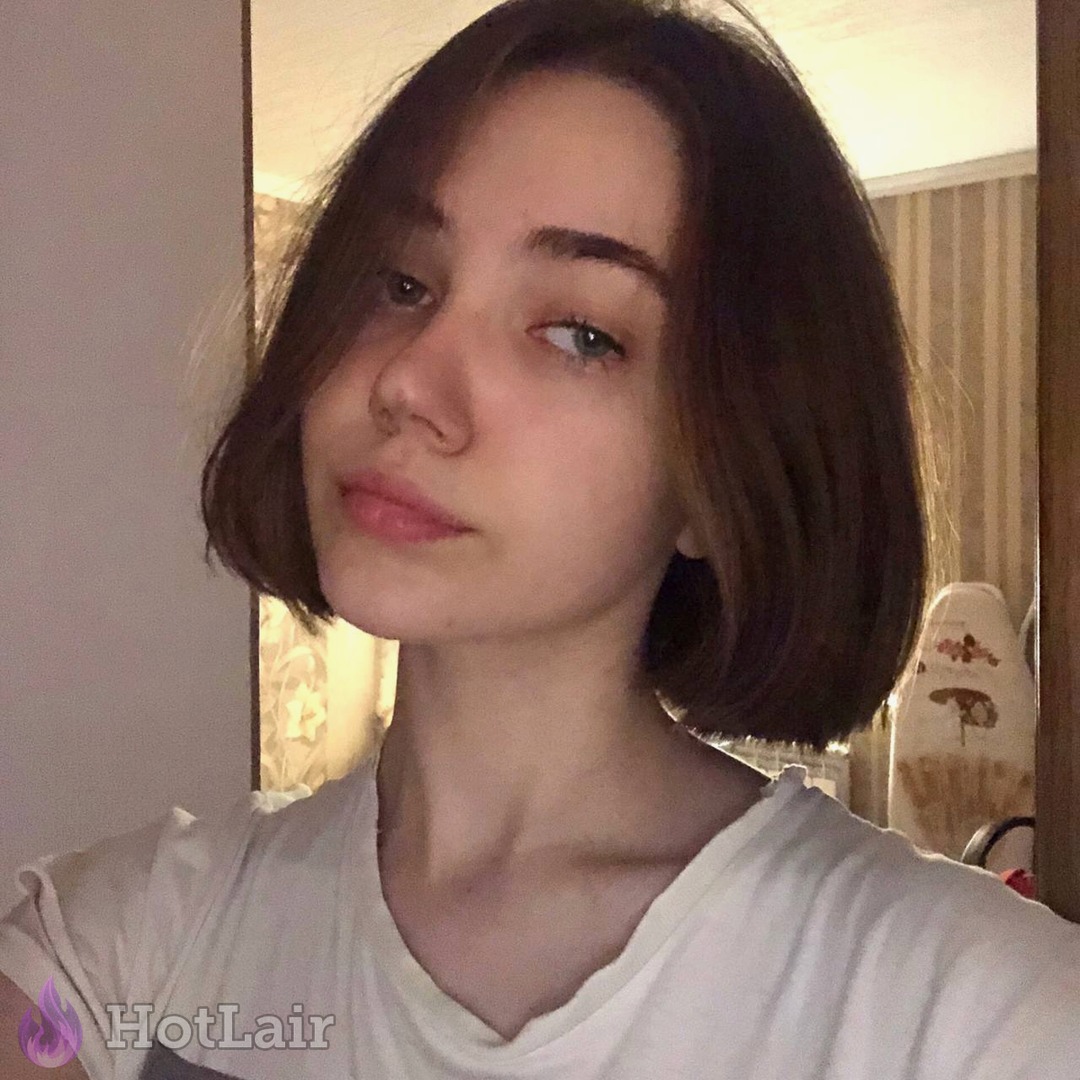 Atractiva morena con cabello corto haciendo selfie en interior