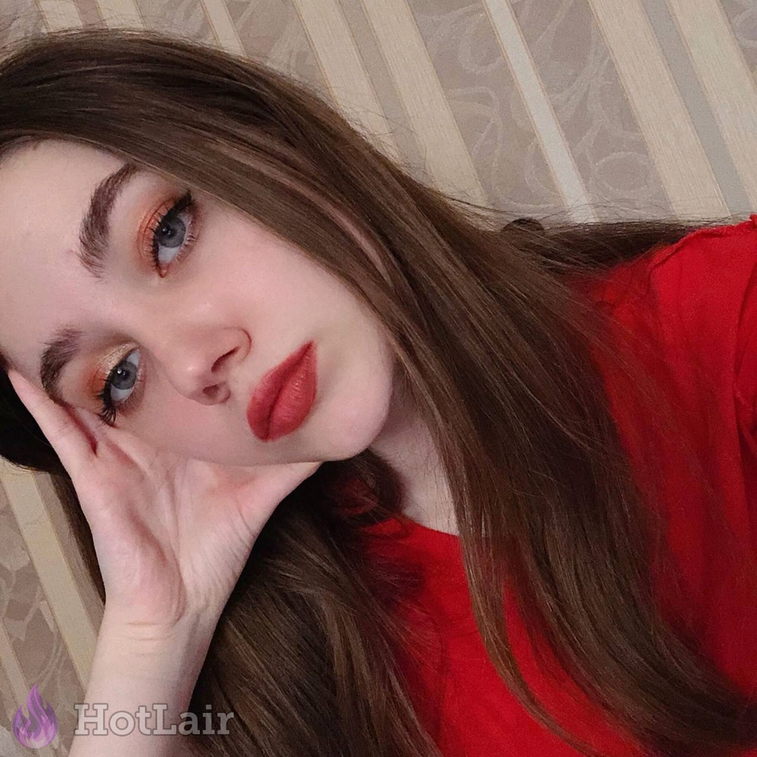 Hermosa chica con cabello castaño largo y lápiz labial rojo acostada, primer plano