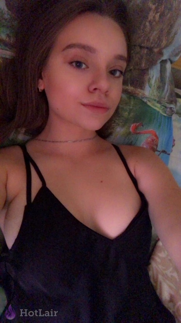 de camisola preta tirando selfie deitada
