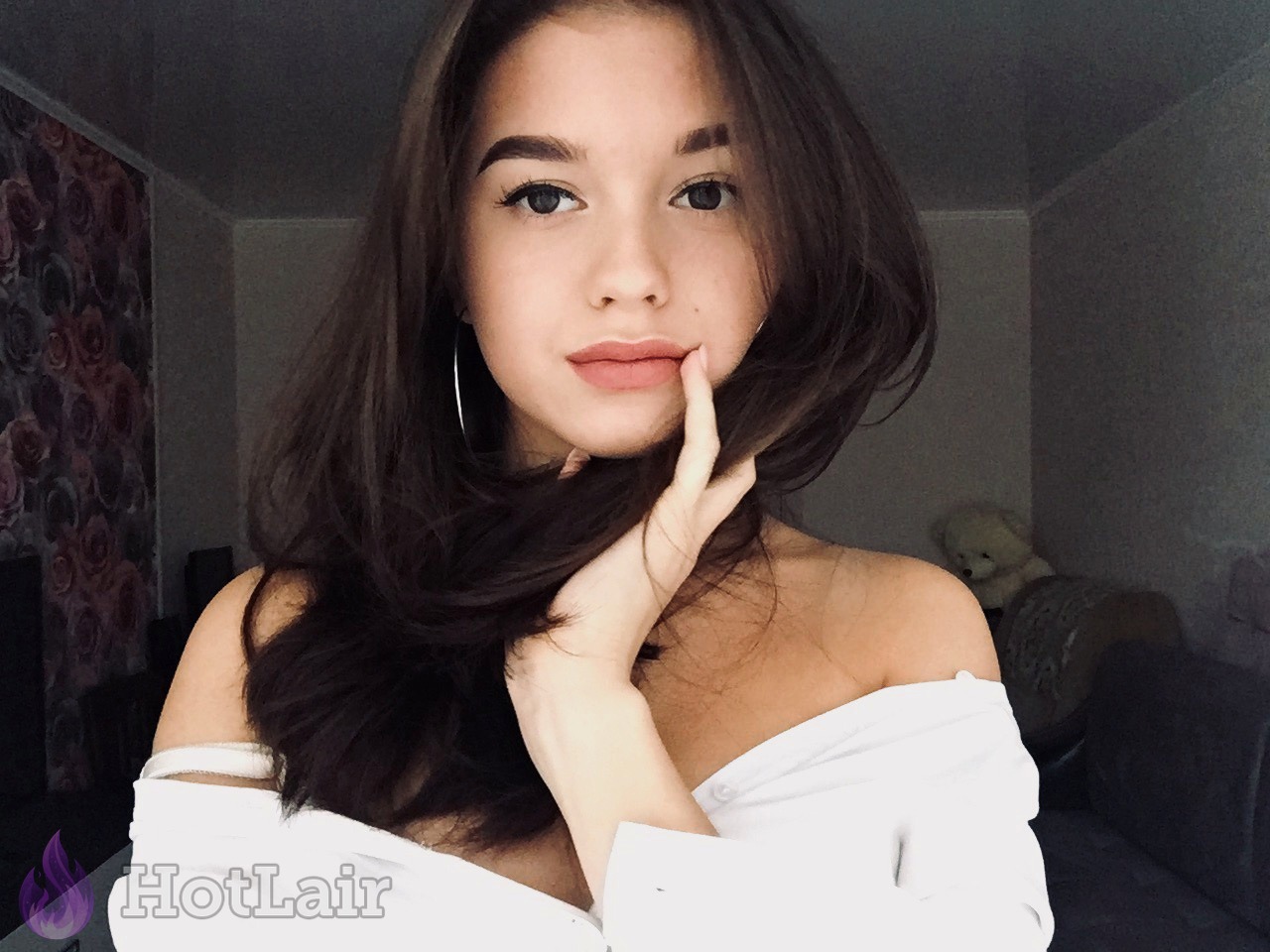 Belle brune posant dans un haut blanc épaules dénudées