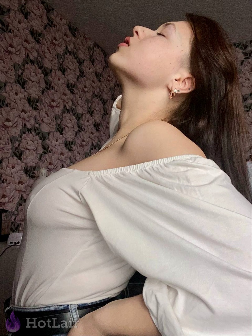 Mujer en blusa blanca con hombros descubiertos posando con la cabeza hacia atrás