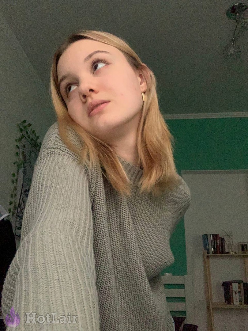 rubia en jersey de punto gris mirando hacia un lado