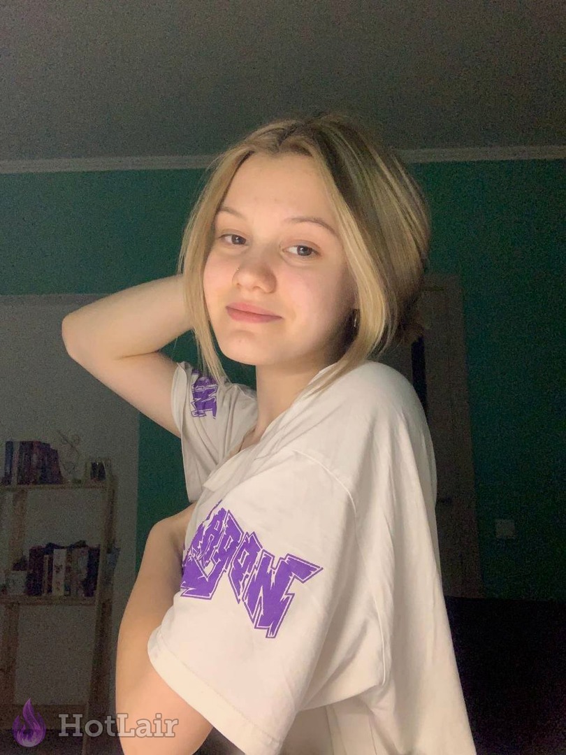 rubia en camiseta blanca oversize posando en interiores