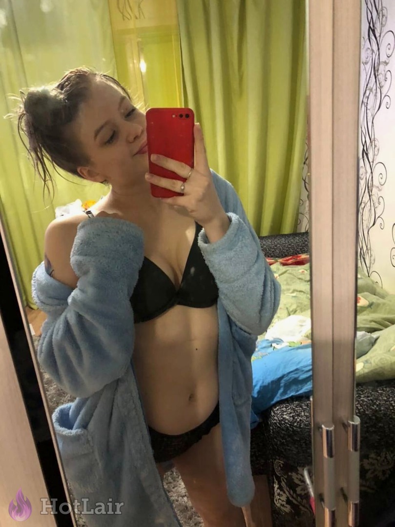 en sujetador negro y bata azul haciéndose selfie en espejo en el dormitorio