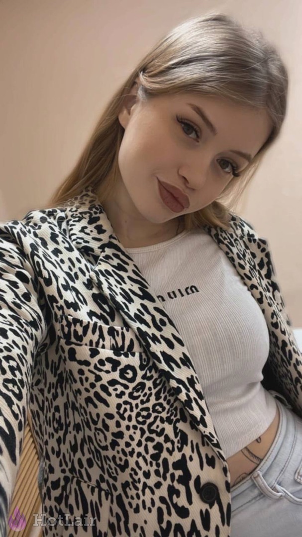 en blazer de leopardo y top blanco haciéndose selfie casual