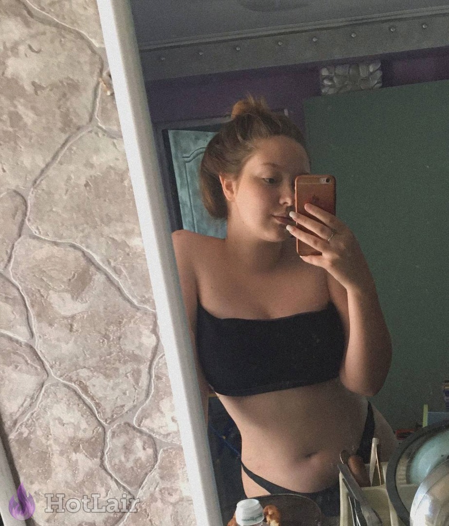en top negro strapless haciéndose selfie en espejo en la habitación