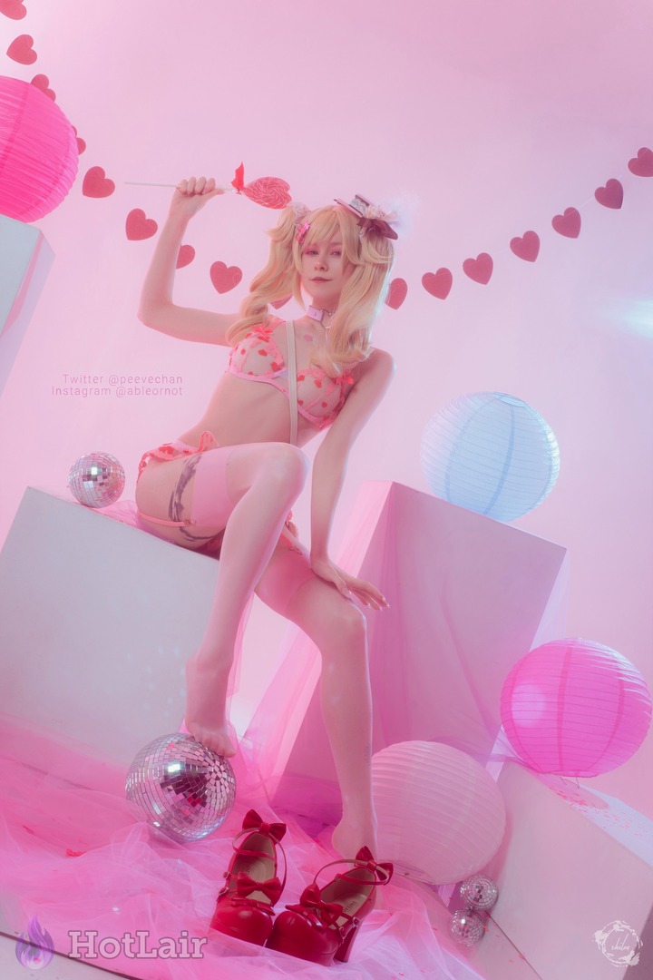 Cosplayeuse blonde en lingerie rose à cœurs posant joyeusement dans une chambre rose avec boules disco