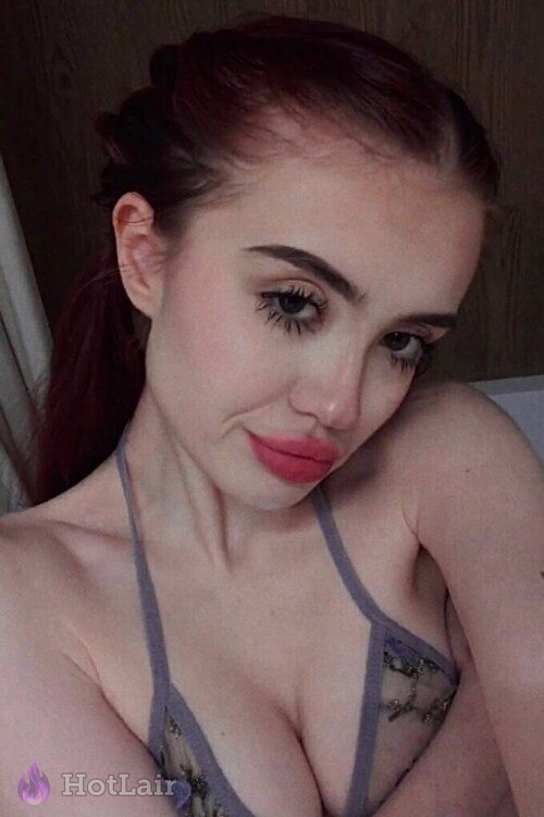 Primer plano de con cabello rojo en lencería gris haciendo cara de beso