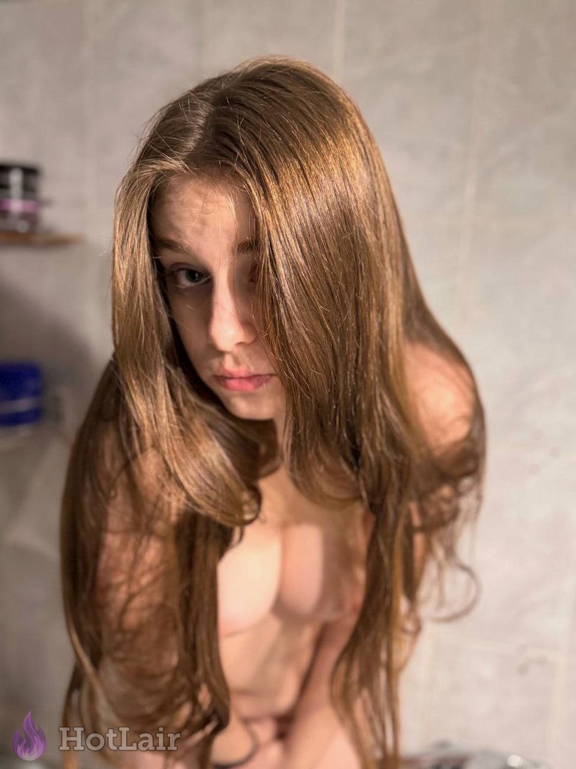 topless con cabello largo mojado posando en el baño