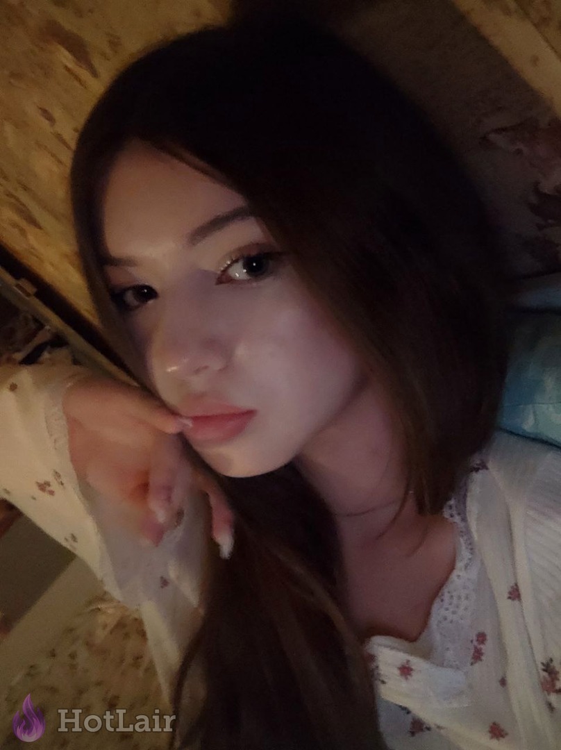 Selfie cercano de atractiva morena con pelo largo en blusa blanca floral