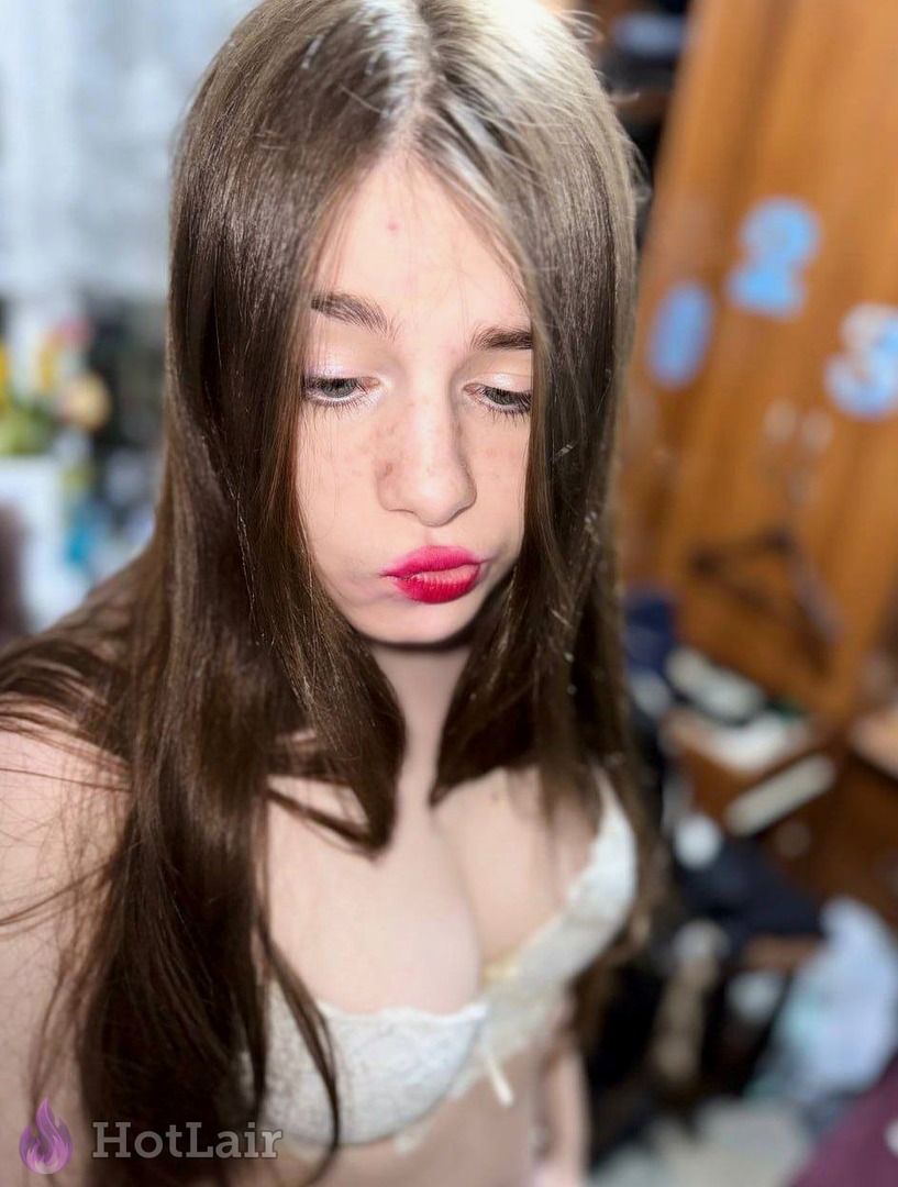 con largo cabello castaño y lápiz labial rojo en sujetador blanco de encaje, mirada seductora hacia abajo