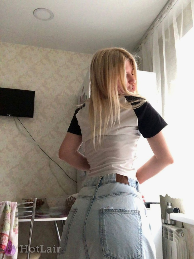 Rubia con jeans y camiseta de bloques de color de espaldas en interior