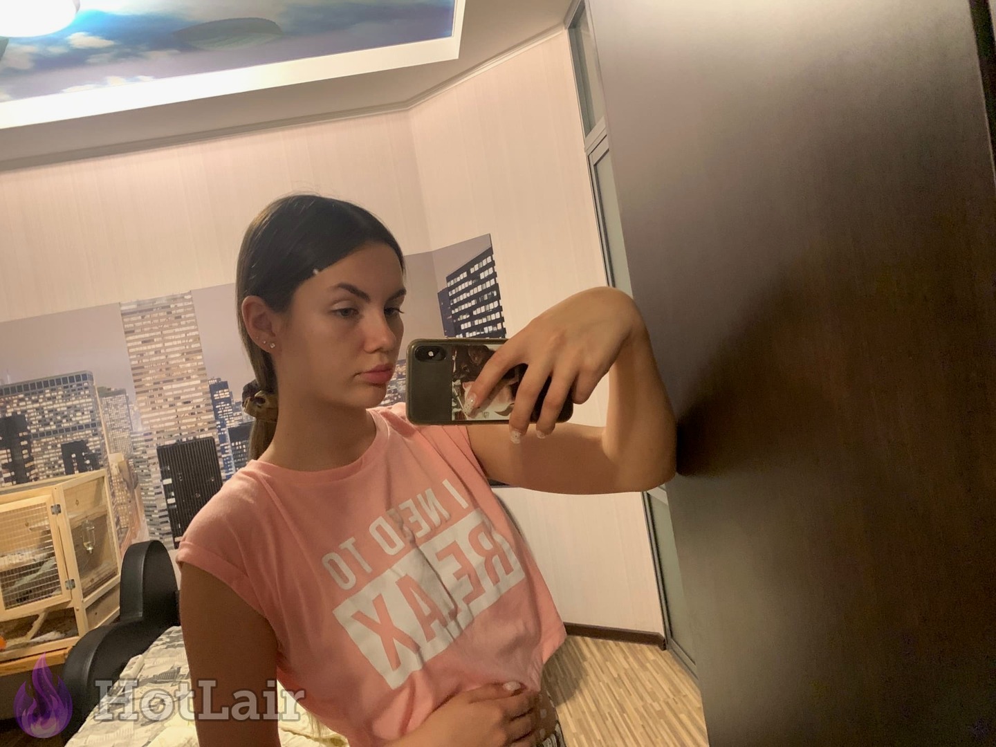 en camiseta rosa haciéndose un selfie en el espejo en dormitorio moderno