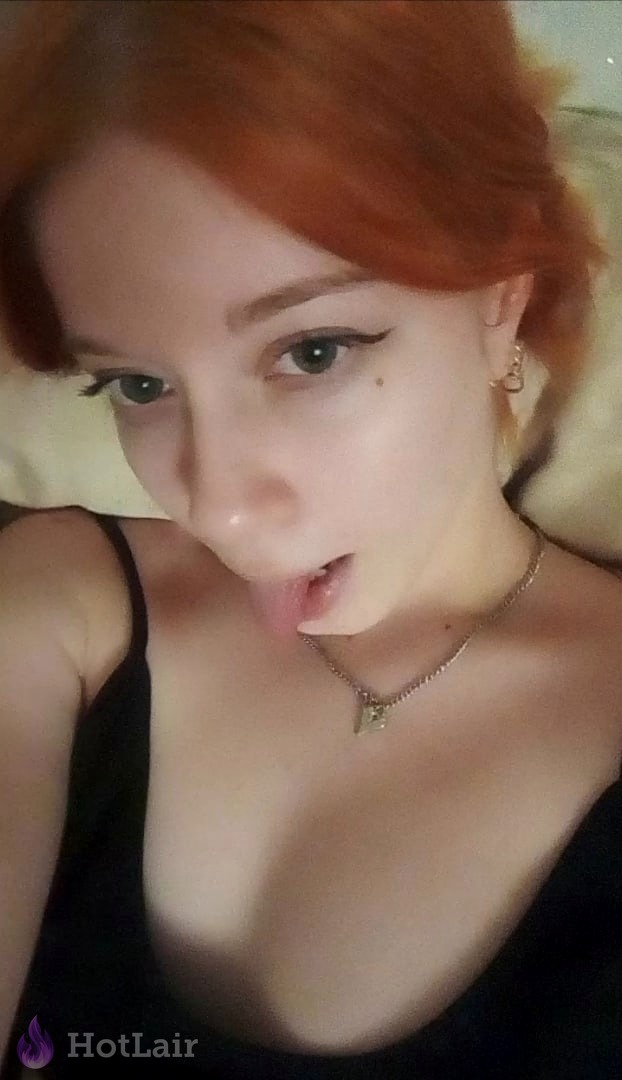 Pelirroja tomando selfie cercano sacando la lengua